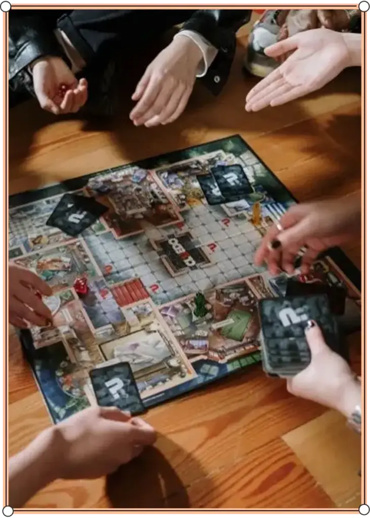 Een groep mensen zit bij elkaar op een houten vloer en speelt een bordspel met kaarten en een kleurrijk speelbord. Ze zijn druk bezig met hun handen, wat zorgt voor een levendige en interactieve sfeer.